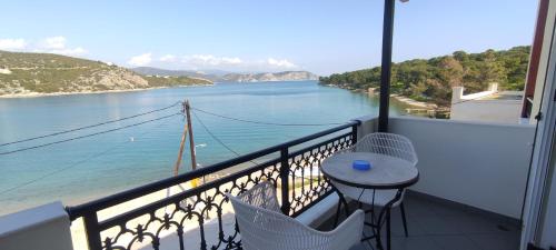 d'un balcon avec une table et une vue sur l'eau. dans l'établissement Vasilis Apartments, à Hermione