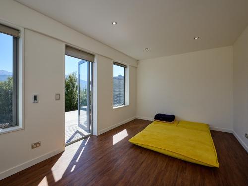 1 dormitorio con 1 cama en una habitación con ventanas en Ata Rangi Lodge - Kaikoura Holiday Home en Kaikoura