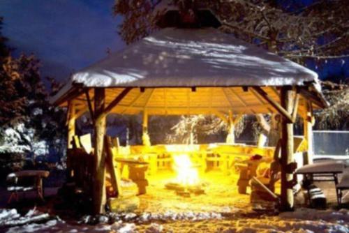 a gazebo with a fire pit in the snow at Pensjonat Lesniczówka bieszczady solina polańczyk in Polańczyk