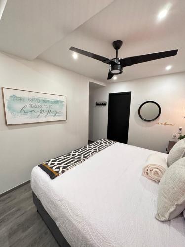 a bedroom with a white bed and a ceiling fan at Entire Luxurious Apartment in Shopping Mall in Mexico City