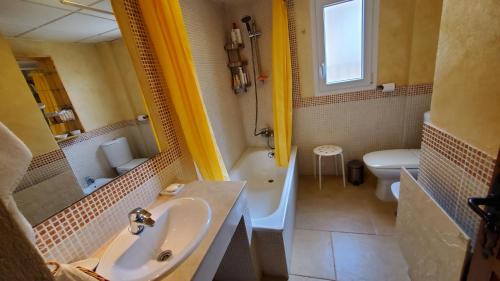een badkamer met een wastafel, een bad en een toilet bij Villa Tahona in Zahara de los Atunes