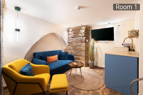 a living room with a blue couch and yellow chairs at Villa Sera in ‘Akko
