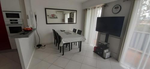 een keuken met een tafel en een televisie in een kamer bij 63 m very bright with beautiful sea view in Antibes