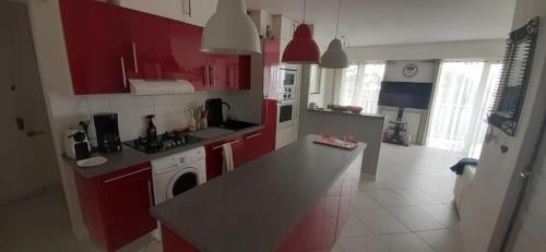 een keuken met rode kasten en een zwart aanrecht bij 63 m very bright with beautiful sea view in Antibes