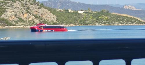 un coche rojo en un cuerpo de agua en Vasilis Apartments, en Ermioni