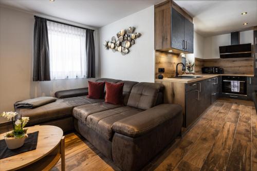 a living room with a brown couch and a table at Ferienwohnung Aigner in Bischofswiesen