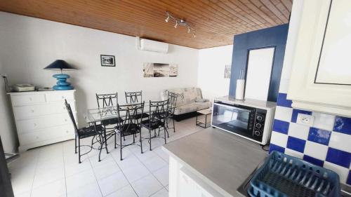 une cuisine et un salon avec une table et des chaises dans l'établissement La Perle des Mtiviers - Sud Nantes, Base Nautique, Thalasso et Golf, à Saint-Jean-de-Monts