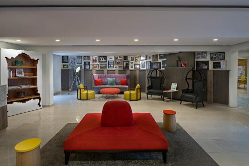 a living room with a red couch and chairs at Maison Fahrenheit in Lagos