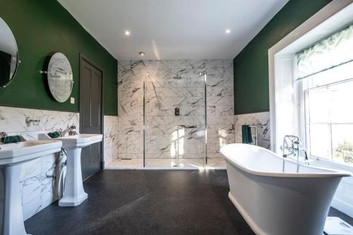 a bathroom with two sinks and a tub and a shower at Georgian Country House -Panoramic Views -Sleeps 12 in Ruthin