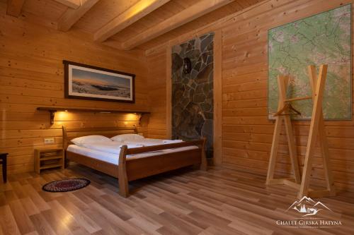 沃羅赫塔的住宿－Girska Hatyna Vorohta，木制客房内的一间卧室,配有一张床