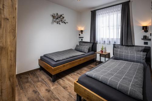 1 dormitorio con 2 camas y ventana en Ferienwohnung Aigner, en Bischofswiesen