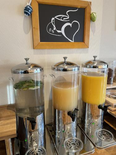 two glass blenders sitting on a counter with orange juice at Hotel Bismarckhöhe in Tecklenburg