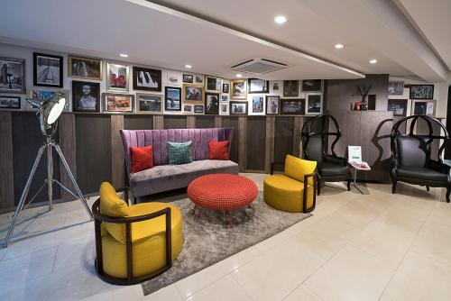 a room with chairs and a couch and a table at Maison Fahrenheit in Lagos