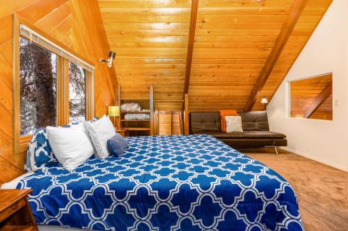 1 dormitorio con 1 cama azul y 1 sofá en Kelly's Chalet, en Girdwood