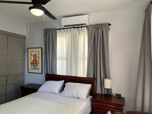 1 dormitorio con cama y ventana en La Estancia Vacation Rentals, en San Juan