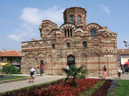 a large brick building with people standing in front of it at The White House in Nesebar
