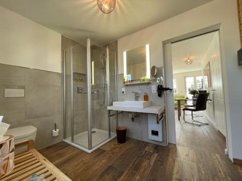 uma casa de banho com um chuveiro, um lavatório e um WC. em Zwischenahner Kaffeemühle em Bad Zwischenahn