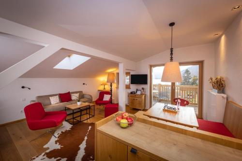 a kitchen and living room with red chairs and a couch at Hapimag Ferienwohnungen Zell am See in Zell am See