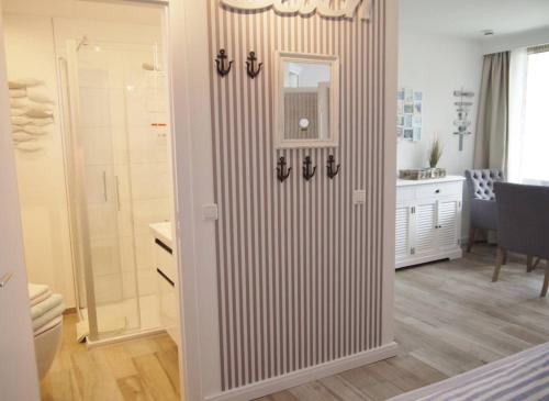 uma casa de banho com uma cabina de duche ao nível do chão ao lado de um quarto em Strandperle 5 em Scharbeutz