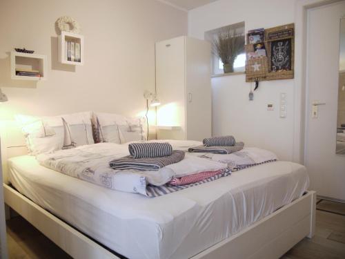 Una cama blanca con toallas en una habitación en Strandperle 5, en Scharbeutz