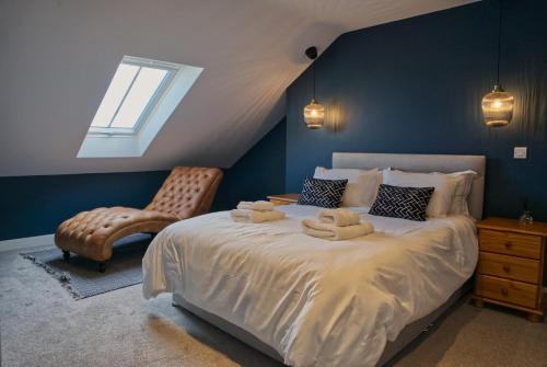 a bedroom with a bed with a chair and a window at Irish Sea Cottage in Annalong