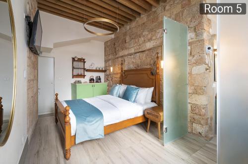 a bedroom with a bed and a brick wall at Villa Sera in ‘Akko