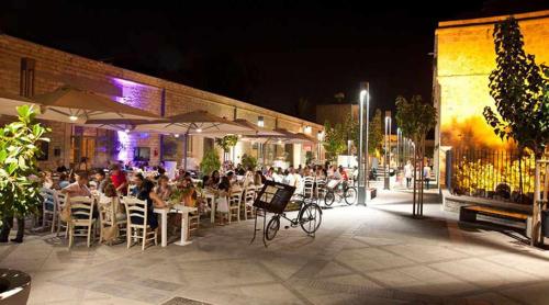 a group of people sitting at tables outside a restaurant at night at Sea Breeze Central, 2bed in Limassol