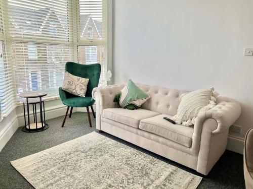 a living room with a couch and a chair and a table at Stunning Flat Close to Beach in Swansea