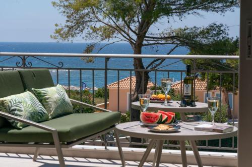 a table and chairs on a balcony with a view of the ocean at Seashell Luxury Residence - Apartment 1 in Lixouri