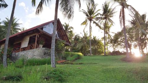 um edifício de resort com palmeiras ao fundo em Villa Pintu Bintang em Pawenang