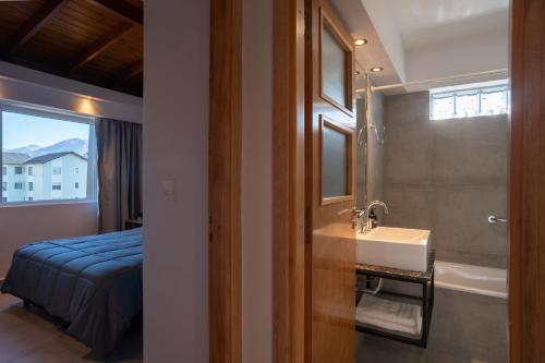 圣卡洛斯-德巴里洛切Portales de la Patagonia Apartments的带水槽、床和镜子的浴室