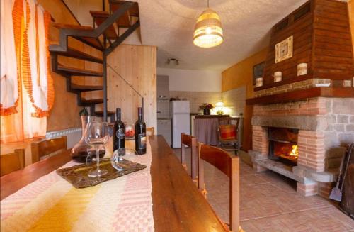 uma cozinha com uma mesa com copos de vinho e uma lareira em CasaGiulia em Sillano