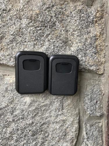 dos cajas negras sentadas sobre una pared de piedra en Hillside Strašín Šumava en Strašín