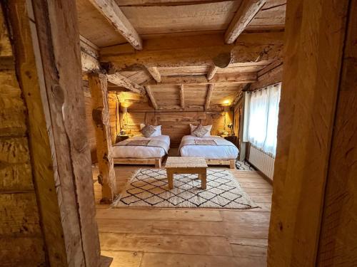 a bedroom with two beds in a log cabin at Hotel Xaluca Spa Aguelmame Sidi Ali in Aguelman