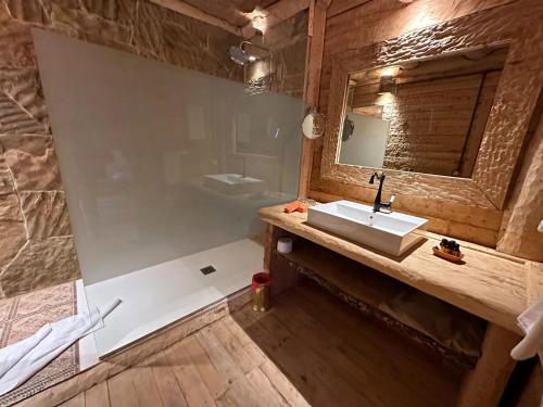a bathroom with a sink and a mirror at Hotel Xaluca Spa Aguelmame Sidi Ali in Aguelman