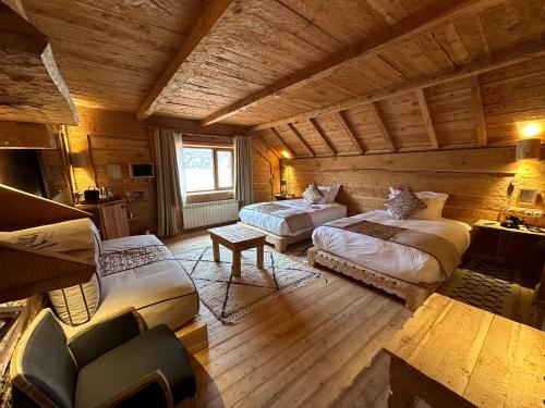 a bedroom with two beds and a couch in a room at Hotel Xaluca Spa Aguelmame Sidi Ali in Aguelman