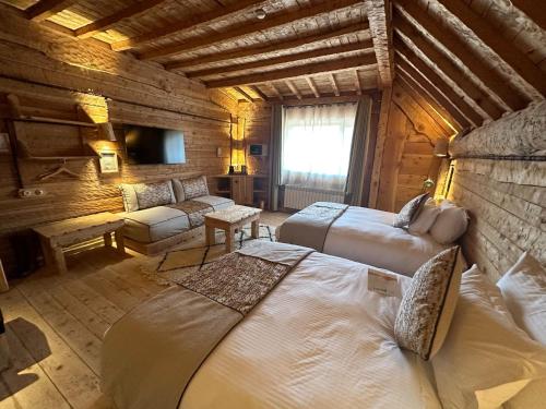 a bedroom with two beds and a couch in a room at Hotel Xaluca Spa Aguelmame Sidi Ali in Aguelman