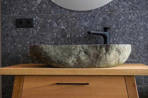 a stone sink sitting on top of a wooden dresser at Lerchpeuntgut Almchalets in Tamsweg