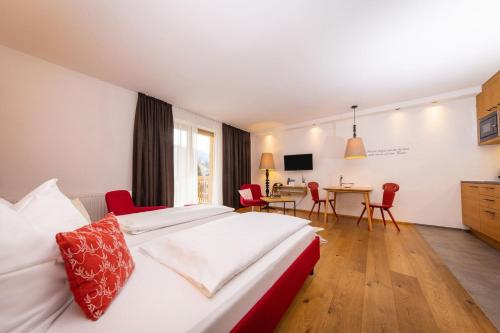a hotel room with a bed and a dining room at Hapimag Ferienwohnungen Zell am See in Zell am See