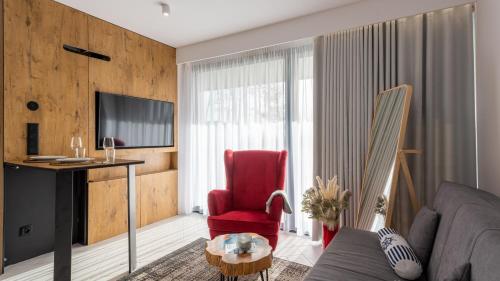 a living room with a red chair and a desk at Sea&Lake, Sun & Snow in Mielno
