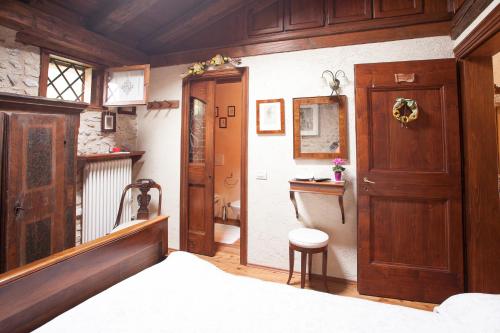 1 dormitorio con 1 cama y puerta de madera en B&B Asolo Casapagnano, en Asolo
