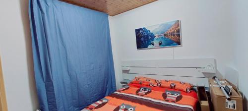 a bedroom with a bed with blue drapes at La casetta di Diego in Abetone