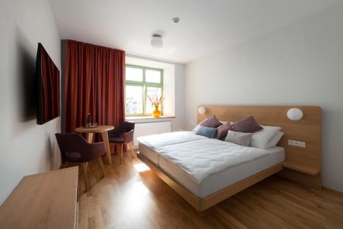 1 dormitorio con cama, mesa y ventana en Hotel Tři knížata en Jihlava