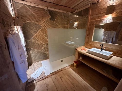 a bathroom with a sink and a mirror at Hotel Xaluca Spa Aguelmame Sidi Ali in Aguelman