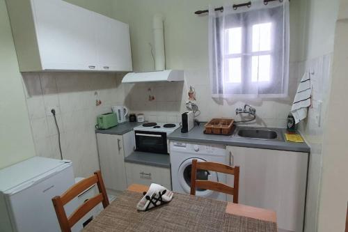 a small kitchen with a stove and a sink at Cosy Messaria in Mesaria