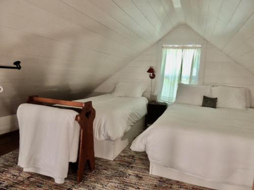 リンカーンヴィルにあるLakefront Cottage by Country House Escapesのベッドルーム1室(ベッド2台、窓付)