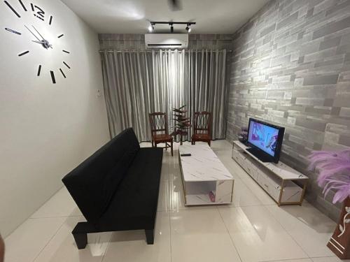 a living room with a couch and a clock on the wall at P' Residence Condo, Batu Kawa, Kuching in Kuching