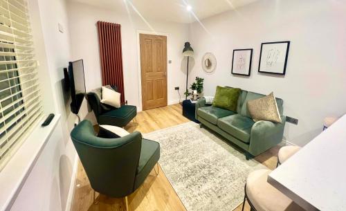 a living room with a green couch and a chair at Gorgeous Newly Renovated 2 Double Bed Flat in Swansea