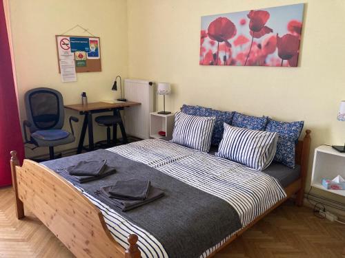 a bedroom with a bed with a desk and a chair at Poppy Flower Apartment in Budapest