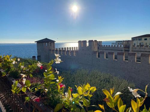 a castle with a bunch of flowers in front of it at Hotel Grifone in Sirmione